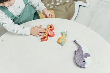 Mädchen spielen, Holzspielzeug, buntes Spielzeug, Meerestiere, Kinderkreativität, lustige Spielzeit, Bildungsspielzeug, Kinderbindung, Indoor-Spiel, Spielzeuginteraktion
