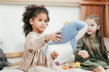 shallow focus, girl, stuffed toy, whale, indoor play, happy childhood, young girls, playing, stuffed animal, indoor scene, children playing
