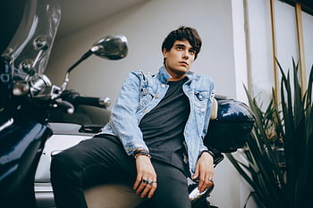 Mann, blaue Jeansjacke, Sitzung, Klassischer Roller, junger Mann, Motorrad, Moderner urbaner Stil, selbstbewusste Pose, Jeansjacke, urbaner Stil