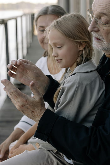 girl with grandparents, sunny porch, touching moment, family bond, granddaughter, grandparents, outdoor setting, multi-generational, love, togetherness, connection