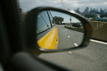 yellow car, highway, urban skyline, rearview mirror, city commute, side mirror, reflection, city road, urban view, car mirror, cityscape