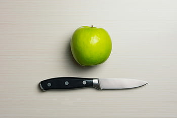 green apple, silver bladed knife, apple beside knife, green fruit, kitchen knife, cutting tool, food preparation, healthy eating, apple on table, knife on table, minimalistic setup