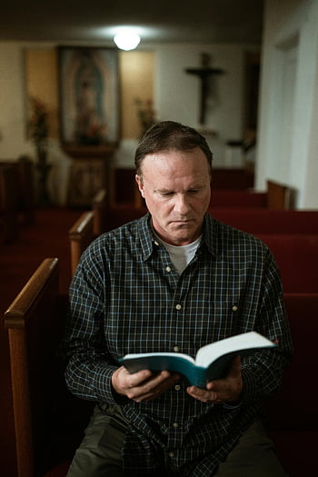 homme lisant la Bible, intérieur paisible de l'église, adulte contemplatif, cadre religieux, bancs d'église, moment spirituel, scène d'église intérieure, lecteur concentré, texte religieux, atmosphère sereine, pratique religieuse