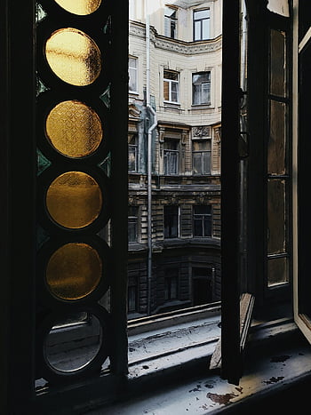 urban apartment view, vintage open window, antique colored glass, cityscape through window, architectural details, urban living, vintage window frame, city view, stained glass window, urban apartment, open window view