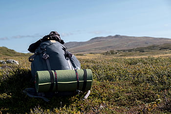 big backpack, mat, grass field, camping gear, Jämtlands län, mountains, hiking, outdoor exploration, scenic Sweden, nature, landscape