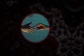 hands reaching, artistic close-up, patterned background, two hands, touching gesture, intimate connection, circular frame, dark background, emotional expression, human interaction, soft lighting