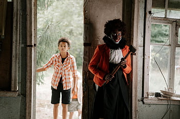 scary clown, ambushing boy, eerie building, abandoned building, clown makeup, child encounter, spooky scene, horror setting, creepy atmosphere, halloween theme, clown costume