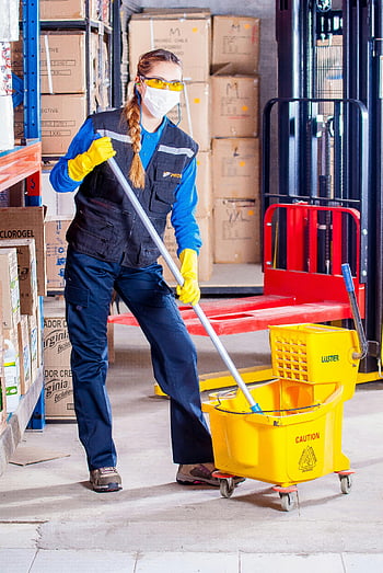 woman holding mop, female janitor, safety gear, cleaning warehouse, mop and bucket, warehouse floor, industrial cleaning, safety equipment, warehouse worker, cleaning supplies, yellow bucket
