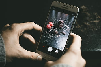 grå samsung smartphone, choklad, hallon, närbild, mörk, smartphone fotografering, matfotografi, samsung telefon, choklad bitar, mörk bakgrund