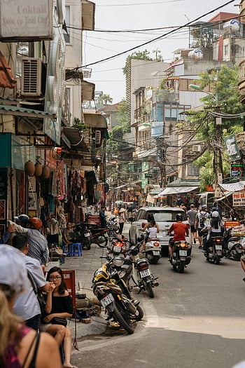 Dong Da, Hanoi, motorbikes, shops, pedestrians, sunny day, street life, sidewalk, vibrant, urban scene, Vietnam