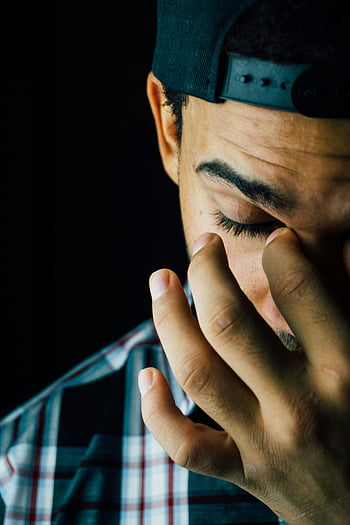 man knijpen de neus, close-up foto, emotionele expressie, Dark Studio, portret, het gezicht van de man, handgebaar, geruite overhemd, zwarte pet, studio verlichting, gezichtsuitdrukking