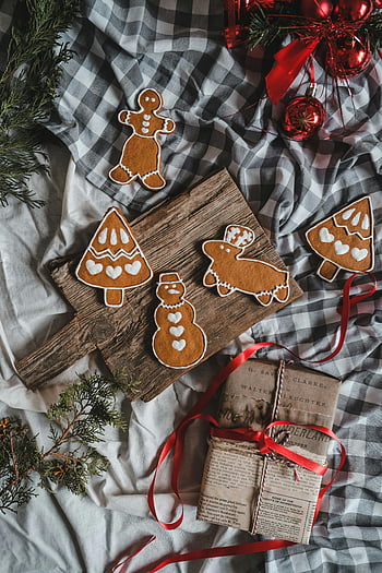 Christmas, gingerbread cookies, wrapped gifts, rustic wooden board, holiday season, cozy arrangement, red ribbon, festive decorations, gingerbread man, gingerbread tree, gingerbread snowman