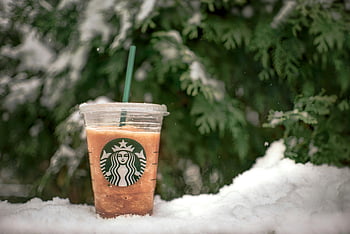 Starbucks drank, ijskoude drank, plastic beker, besneeuwde achtergrond, groenblijvende bomen, winters tafereel, Starbucks-logo, verfrissend drankje, buiten instelling, koud weer, close-up foto