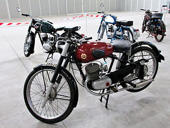 Montesa Brio, motos anciennes, vélos classiques, exposition intérieure, design rétro, collection de motos, réservoir rouge, cadre noir, moteur argenté, vélo bleu, siège noir
