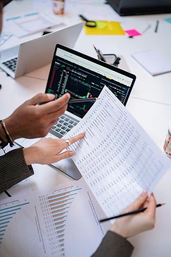 samenwerkingskantoor, handen die documenten vasthouden, gegevens analyseren, laptop, wit printerpapier, kantooromgeving, data-analyse, samenspel, zakelijke bijeenkomst, Financiële gegevens, werkomgeving