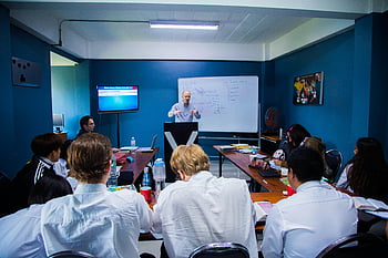 business seminar, people listening, modern classroom, speaker, attentive audience, whiteboard, presentation, educational setting, group learning, professional development, training session