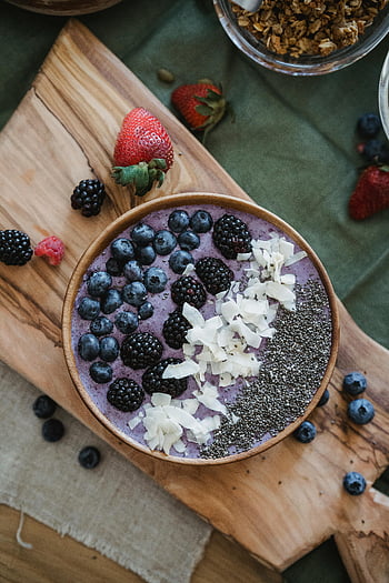 Berry Smoothie Bowl, Chia semínka, kokosový ořech, zdravá snídaně, hnědá dřevěná mísa, bobule, lichotník mísa, kokosové vločky, Chia Seeds topping, dřevěné prkénko, čerstvé jahody