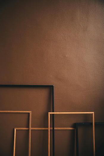 empty frames, leaning on wall, wooden frames, brown wall, minimalist design, artistic arrangement, empty picture frames, interior decor, wall art, home decor, minimalist style