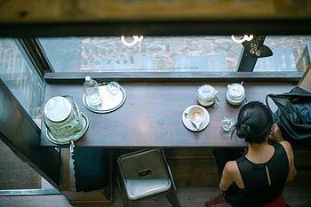 coffee shop, woman drinking coffee, cozy cafe, modern coffee shop, quiet coffee break, cafe interior, coffee cup, cafe table, cafe window, woman sitting at cafe, cafe atmosphere