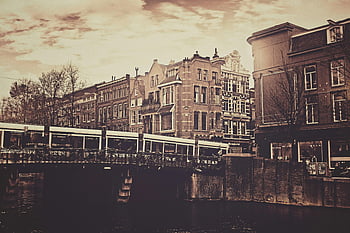 sepia photography, bridge, concrete house, vintage style, Amsterdam architecture, canal, tram, crossing bridge, urban scene, cityscape, Netherlands