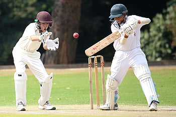 boys playing cricket, cricket players, skillful batting, wicket-keeping, sunny day, cricket action, outdoor sports, cricket field, cricket equipment, cricket match, cricket players in action