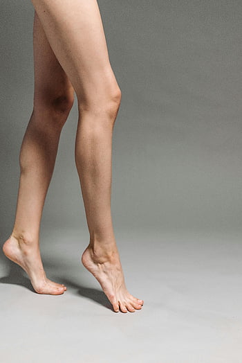 tiptoeing, bare legs, close-up, skin tone, skin texture, simple backdrop, tiptoe, human legs, natural skin, minimalistic photography, human feet