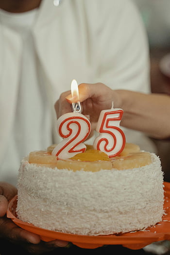 25. narozeniny, narozeninový dort, svíčky, oslava, ovocná poleva, bílá poleva, Oranžová deska, ruční drží dort, Světlé svíčky, kokosový dort, Slavnostní dort