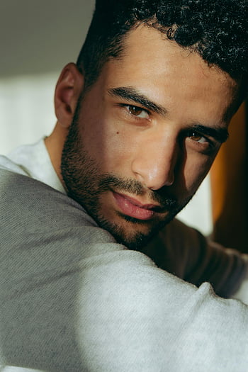 uomo in bianco, colpo del primo piano, uomo di bell'aspetto, capelli ricci, peli del viso, guardando la fotocamera, luce del sole, ombre cinesi, bell'uomo, ritratto di Close-up, collo alto bianco
