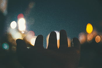 bokeh photography, hand, colorful bokeh lights, night, mysterious atmosphere, dreamy atmosphere, bokeh effect, night photography, hand reaching, bokeh lights, dreamy mood