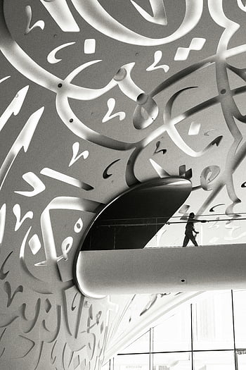 modern architectural design, Arabic calligraphy, Dubai museum, elegant design, intricate calligraphy, modern architecture, interior design, cultural art, contemporary design, black and white photography, museum exhibit