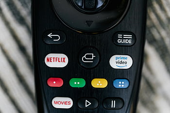 remote control, close-up shot, TV remote, streaming service buttons, Netflix button, Prime Video button, detailed image, guide button, movies button, black remote, close-up image