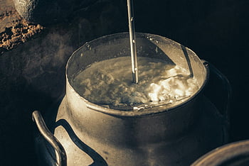 milk, close-up shot, creamy milk, vintage metal container, churned milk, traditional dairy methods, dairy, metal jar, churning, close-up, dairy process