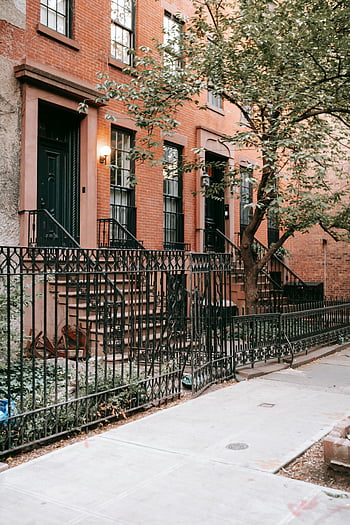 historic brownstone buildings, lush greenery, classic urban neighborhood, brownstone houses, urban architecture, cityscape, residential area, historic homes, urban living, neighborhood charm, city life