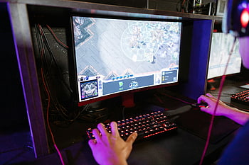 person playing computer game, online gaming session, modern setup, technology, recreation, gaming monitor, keyboard, mouse, headphones, gaming setup, RGB lighting
