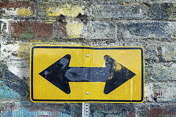 Signale à deux voies jaune et noir, signe jaune altéré, mur de briques rustiques texturés, Style d'art urbain, panneau de rue à double sens, signe altéré, mur rustique, art urbain, Panneau de signalisation, panneau jaune, mur de briques