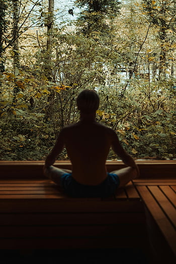 man meditating, forest meditation, serene environment, peace and tranquility, back view, sitting meditation, natural setting, outdoor meditation, calm atmosphere, woodland scene, meditation practice