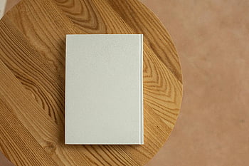 bílá kniha, dřevěný stůl, minimalistický design, kopie prostor, texturované dřevo, jednoduché pozadí, čistá estetika, Prázdná kniha, ploché ležel, pohled shora