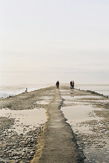 people walking, seawall, Figueira da Foz, Portugal, serene walk, breakwater, coastal backdrop, seaside, waterfront, ocean view, tranquil scene