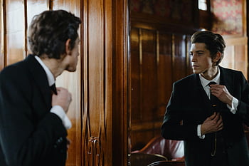 man fixing necktie, elegant man, formal attire, fixing tie, mirror reflection, man in suit, adjusting tie, formal wear, man in mirror, suit and tie, elegant attire