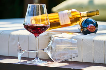 verre de vin, vin rouge, salon extérieur, cadre confortable, moment de détente, bouteilles de vin, photo en gros plan, Verre propre, dégustation de vins, détente extérieure, verrerie
