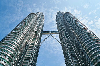 Petronas Twin Towers, Kuala Lumpur, low-angle photography, iconic architecture, bright blue sky, modern skyscrapers, Malaysia landmarks, urban skyline, twin towers, architectural marvel, cityscape view