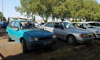 Opel Corsa, Ford Scorpio, 1990 autos, Chalon sur Saone, coches antiguos, coches estacionados, Autos europeos, auto compacto, coche de sedán, matrículas de coche, estacionamiento forrado con árboles