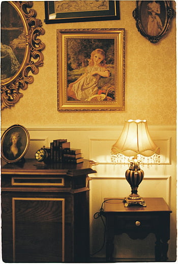 vintage room, classic decor, gold framed painting, illuminated lamp, side table, warm lighting, antique furniture, charming room, wall art, vintage lamp, vintage interior