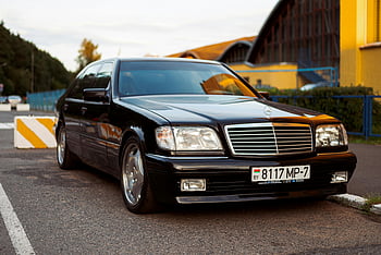 Black Mercedes-Benz, luxury sedan, parking lot, Minsk, sleek automotive, black car, license plate, elegant parking, Mercedes-Benz car, automotive scene, luxury vehicle