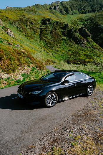 Peugeot 508, black car, rural road, lush green mountains, winding road, bright daylight, outdoor scene, automobile, scenic landscape, Peugeot, nature backdrop