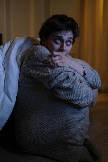 ængstelig kvinde, svagt oplyst rum, Natstress, sidder på gulvet, Bekymret udtryk, følelsesmæssig nød, indendørs indstilling, ensom figur, mentalt helbred, Bekymring om natten, stress og bekymring