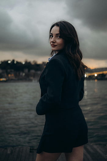 donna in blazer nero, Mini gonna nera, in posa dal fiume, tacchino, crepuscolo, eleganza, moda all'aperto, Ritratto serale, Vestito alla moda, Scena sul lungomare, modello femminile
