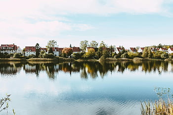 village houses, rippling water, calm lake, peaceful scene, clear sky, summer day, house reflection, lakeside village, serene landscape, residential area, natural beauty