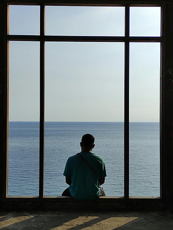 muž sedící u okna, zpětný pohled, pohled na oceán, klidný oceán, samota, odraz, parapet, výhled na moře, osamělý muž, klidné scény, rozjímání