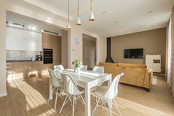 Esstisch, Stühle, Küche, modernes Design, natürliche Beleuchtung, Geräumiges Wohnzimmer, Zeitgenössisches Interieur, Open-Plan-Layout, weiße Möbel, Holzboden, Pendelleuchten